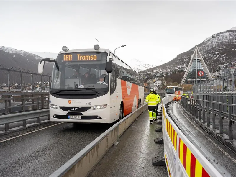 Arbeidsfolk og maskiner på Tromsøbrua.  Buss passerer. - Klikk for stort bilde