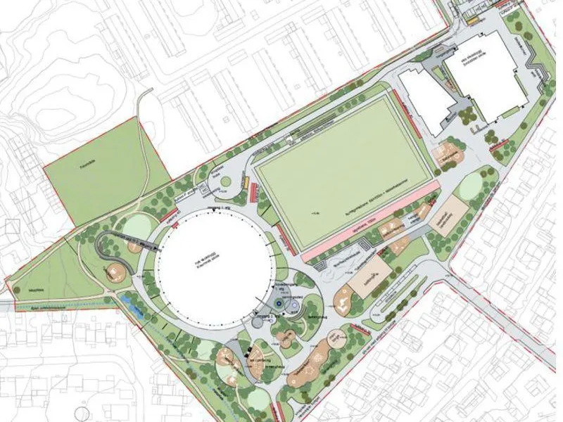 Situasjonsplan for den nye skolen og idrettsanlegget viser en sirkelrundt skolebygg i nordøst og fotballbane mot vest.