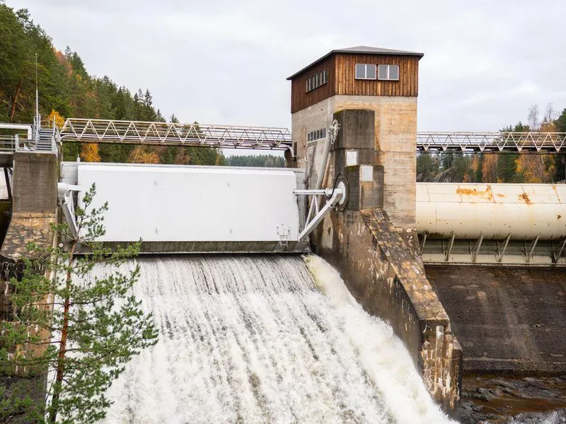 Dam, vann, kraftverk, skog, himmel. Foto.