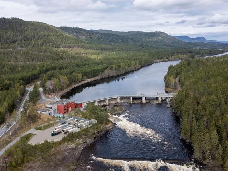Kraftverk, dam, elv, anleggsområde, skog, himmel. Foto.