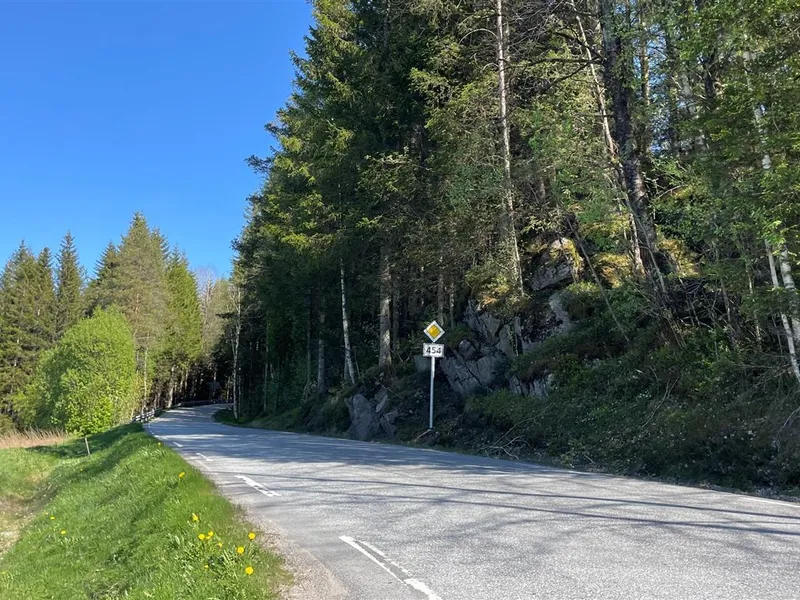 Foto av parti av fylkesveg 454 ved Kjåkleiva med liten grøft mot fjell - Klikk for stort bilde